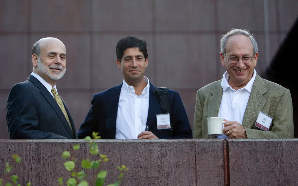 Kevin Warsh standing between Ben Bernanke and Donald Kohn at an outdoor event — The Coinomist