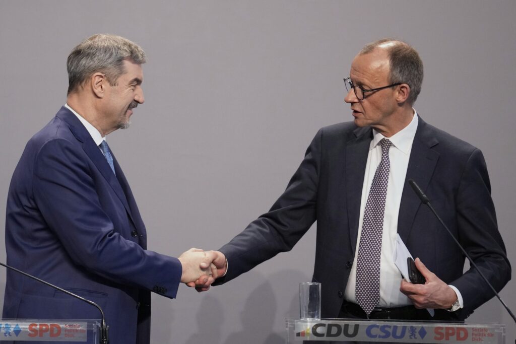 Friedrich Merz and Markus Söder shaking hands on stage after finalizing the German coalition agreement, April 2025.