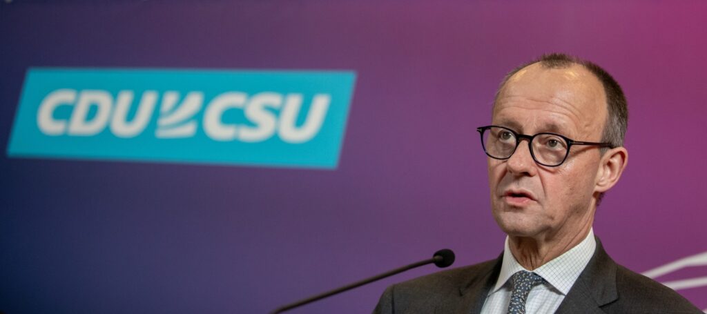 Close-up of Friedrich Merz speaking against a CDU/CSU backdrop during a 2025 political event in Berlin.