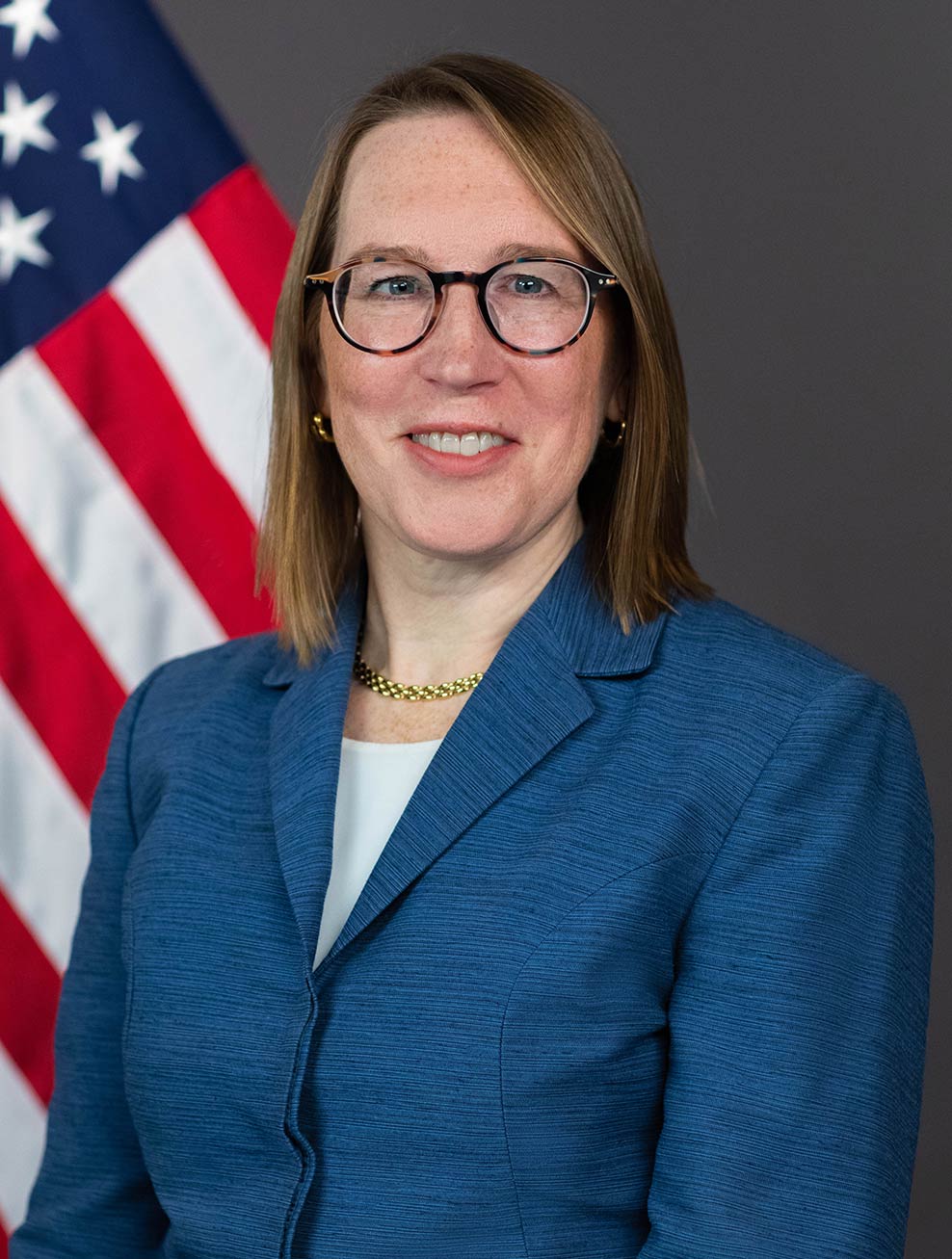 A photo of U.S. SEC Commissioner Hester Peirce with the U.S. flag in the background - The Coinomist