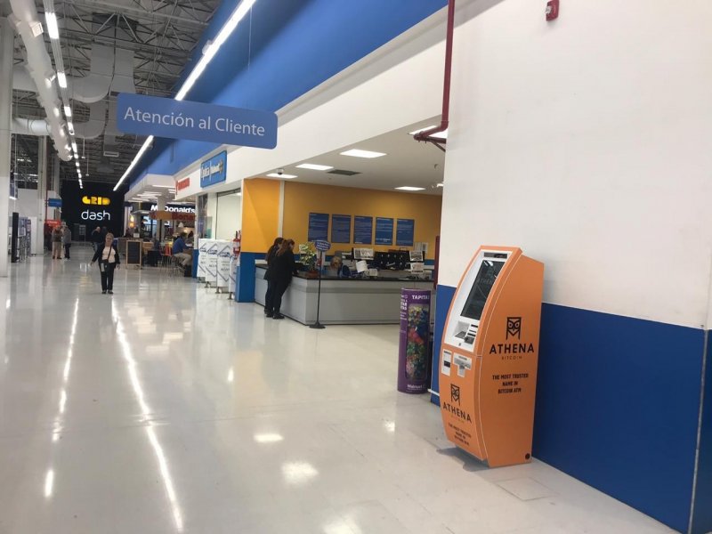 An orange Genesis Coin Bitcoin ATM placed inside a Buenos Aires Walmart, just steps from checkout counters and daily errands — illustrating the casual integration of crypto in public spaces. — The Coinomist