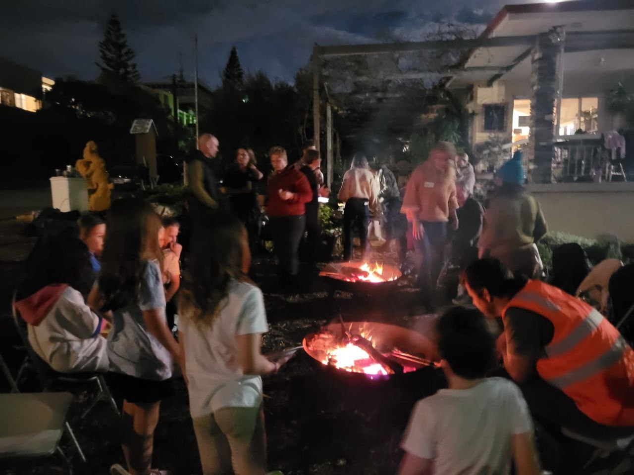 Cabin DAO members gathered around fire pits for a summer evening meetup—real-world bonding, offline coordination, and slow conversation under the stars — The Coinomist