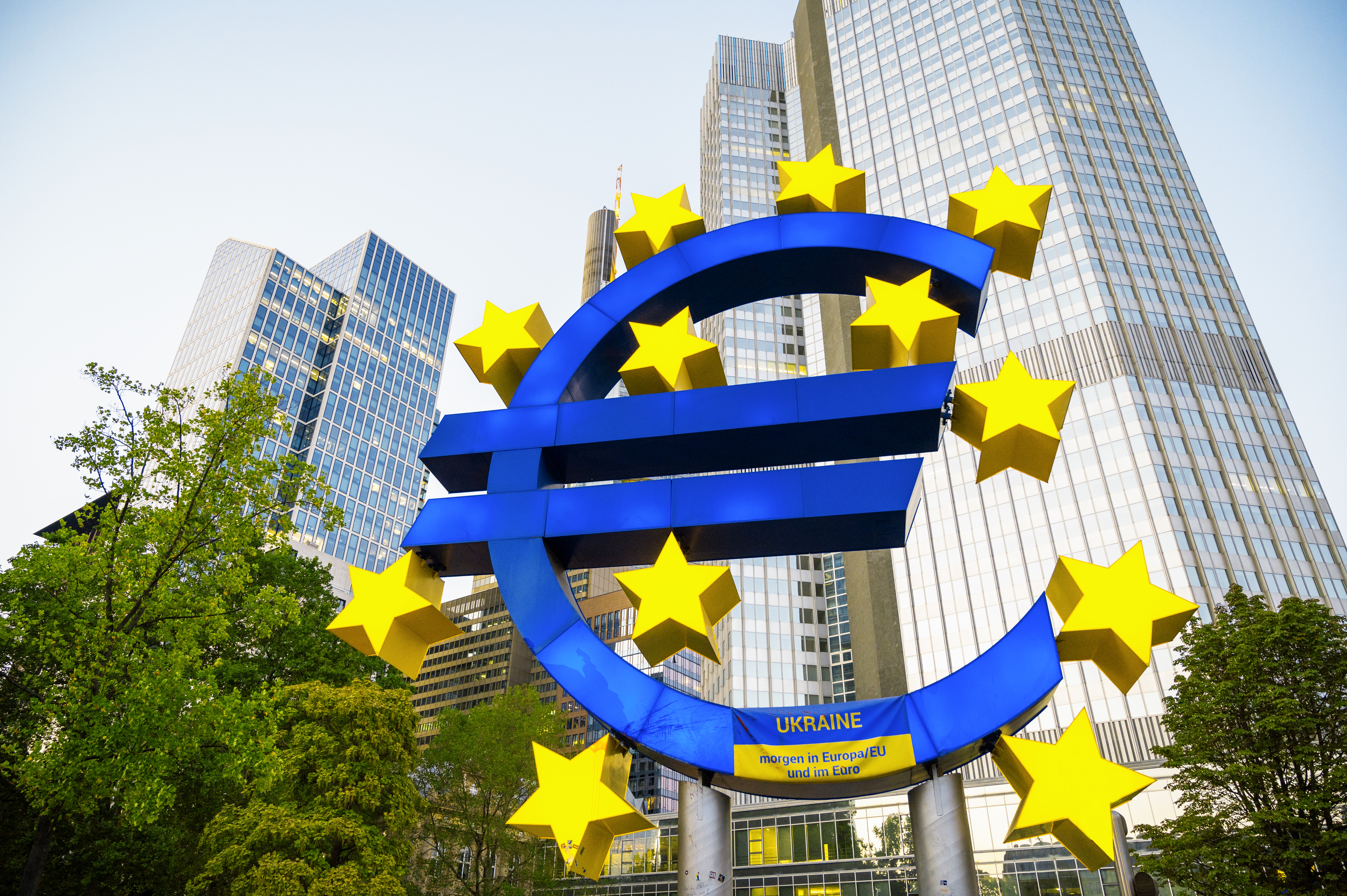 A large blue Euro sculpture surrounded by yellow stars stands prominently in front of the European Central Bank (ECB) headquarters in Frankfurt, Germany - The Coinomist